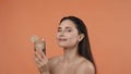 Skincare creative concept. Woman holding glass of water with lime slices and looking smiling at the camera. Royalty Free Stock Photo