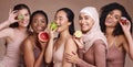 Skincare, diversity and women with fruit for beauty, nutrition and group diet on a studio background. Vitamin c, happy