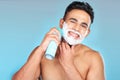 Skincare, face and man with shaving cream in studio on a blue background. Portrait, hair care or happy male model from