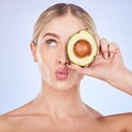 Skincare, face and woman with avocado in studio isolated on a blue background. Cosmetics kiss, fruit and thinking female
