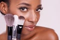 Skincare, makeup brushes and portrait of black woman with brush on face in studio with cosmetic application tool. Skin Royalty Free Stock Photo