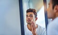 Skincare, man looking in a mirror and face in bathroom with lens flare. Body treatment or cosmetics for wellness Royalty Free Stock Photo