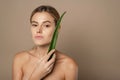 Skincare, moisturizing. Beauty Woman with perfect skin holding fresh leaf of Aloe Vera. Woman with natural makeup and healthy skin Royalty Free Stock Photo