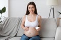 Skincare During Pregnancy. Beautiful Pregnant Woman Applying Moisturising Cream On Naked Belly