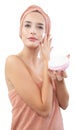 Skincare, pretty young woman applying moisturizing cream on face, lotion or mask for skin lifting and anti-aging, wears wrapped Royalty Free Stock Photo