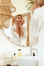 Skincare Routine. Woman With Patches Under Eyes Standing In Bathroom And Looking At Mirror. Lady In Fashion Silk Pajama.