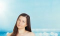 Skincare and sun protection in summer. Portrait of a beautiful young suntanned woman, blue sea and sky on background