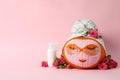 Skincare supplies, pumpkin with eye patches and towel on pink background Royalty Free Stock Photo
