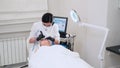 Aesthetician performs Hydrafacial on client in modern beauty clinic. Skincare treatment with hydradermabrasion machine