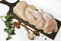 Skinless raw chicken thighs with ingredients for cooking on a wooden cutting board on white background Royalty Free Stock Photo