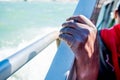 Close up of thin and skinny african migrant man hand on boat while crossing mediterranean sea to europe on sunny day as symbol of