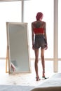 Skinny anorexic woman standing on weight scales near the mirror Royalty Free Stock Photo