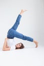 skinny caucasian pretty female lying on floor at white studio with legs raised