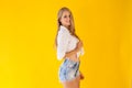 Skinny girl posing on a yellow background fashion blonde Royalty Free Stock Photo