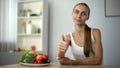 Skinny girl showing thumbs up, recommending vegetables, health, proper nutrition