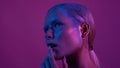 Beautiful female model posing in blue and pink neon light in studio