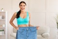 Skinny Woman Comparing Oversize Jeans After Weight Loss At Home