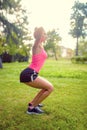 Skinny woman in park, doing squats and running at sunset