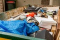 Skip bin full of household waste rubbish on the front yard