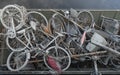 Skip with heap of rusty muddy bicycles
