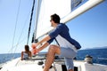 Skipper navigating the sailing boat, woman relaxing