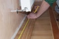 Skirting Board & Architrave. Repairman`s hands Installing Skirting Board Oak Wooden Floor.