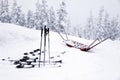 Skis with bindings, ski poles and an empty cradle for transporting people and products to the mountain covered with snow at ski r Royalty Free Stock Photo