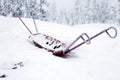 Skis with bindings, ski poles and an empty cradle for transporting people and products to the mountain covered with snow at ski r Royalty Free Stock Photo