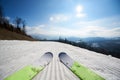 Skis on white snowy ski track, winter mountain landscape and blue sky copy space background. Royalty Free Stock Photo