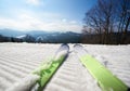 Skis on white snowy ski track, winter mountain landscape and blue sky copy space background. Royalty Free Stock Photo