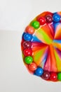 Skittles candy with sugar and water merge into colorful rainbow portal in vertical background asset with white behind it