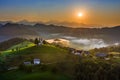 Skofja Loka, Slovenia - Aerial panoramic view of amazing golden foggy sunrise at the beautiful hilltop church of Sveti Tomaz Royalty Free Stock Photo