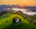 Skofja Loka, Slovenia - Aerial panoramic view of the beautiful hilltop church of Sveti Tomaz Saint Thomas with golden sunrise Royalty Free Stock Photo