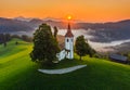 Skofja Loka, Slovenia - Aerial view of the beautiful hilltop church of Sveti Tomaz Saint Thomas with amazing golden sunrise