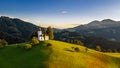 Skofja Loka, Slovenia - Aerial view of the beautiful hilltop Sveti Tomaz Saint Thomas church with a warm summer sunset Royalty Free Stock Photo