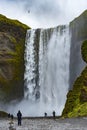 Skogafoss waterfall ion Iceland with a few silhouettes of tourists