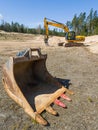 Skrunda, Latvia - May 3, 2022: Yellow excavator JCB JS 220 LC and removed rusty excavator bucket is located in a quarry