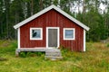 Skuleskogen, Sweden - 08.22.2021: Red wooden cabin in the forest of Skuleskogen national park in Sweden on a cloudy day