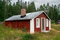 Skuleskogen, Sweden - 08.22.2021: Red wooden cabin in the forest of Skuleskogen national park in Sweden on a cloudy day