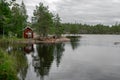 Skuleskogen, Sweden - 08.22.2021: Red wooden cabin by sea shore in the forest of Skuleskogen national park in Sweden on Royalty Free Stock Photo