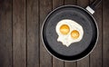 Skull fried egg on skillet on wooden background