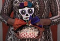Skull gift full of popcorn held by a woman.