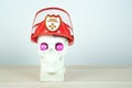 Skull sculpture wearing a red helmet and bright pink eyes. Copy space. fireman parody