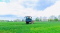 Skutec, Czech Republic, 17 May 2021: Tractor spraying pesticides on vegetable field with sprayer.