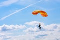 Skutech, Czech Republic, 6 August 2020: A parachutist with an orange parachute canopy blue sky and white clouds