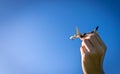 Sky background. White toy plane flight in pilot hand on sunlight blue background. airplane travel in bright sun light