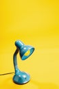 Sky-blue desk lamp on yellow background. Royalty Free Stock Photo