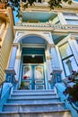 Sky blue house of The Painted Ladies entrance with red flower and 712 above Victorian doors