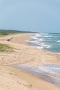 The sky is clean, paradisiac beach on the brazialian coast, the atlantic sea has foamy waves, marks of footprints and Royalty Free Stock Photo