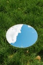 sky and cloud reflection in round mirror on grass Royalty Free Stock Photo